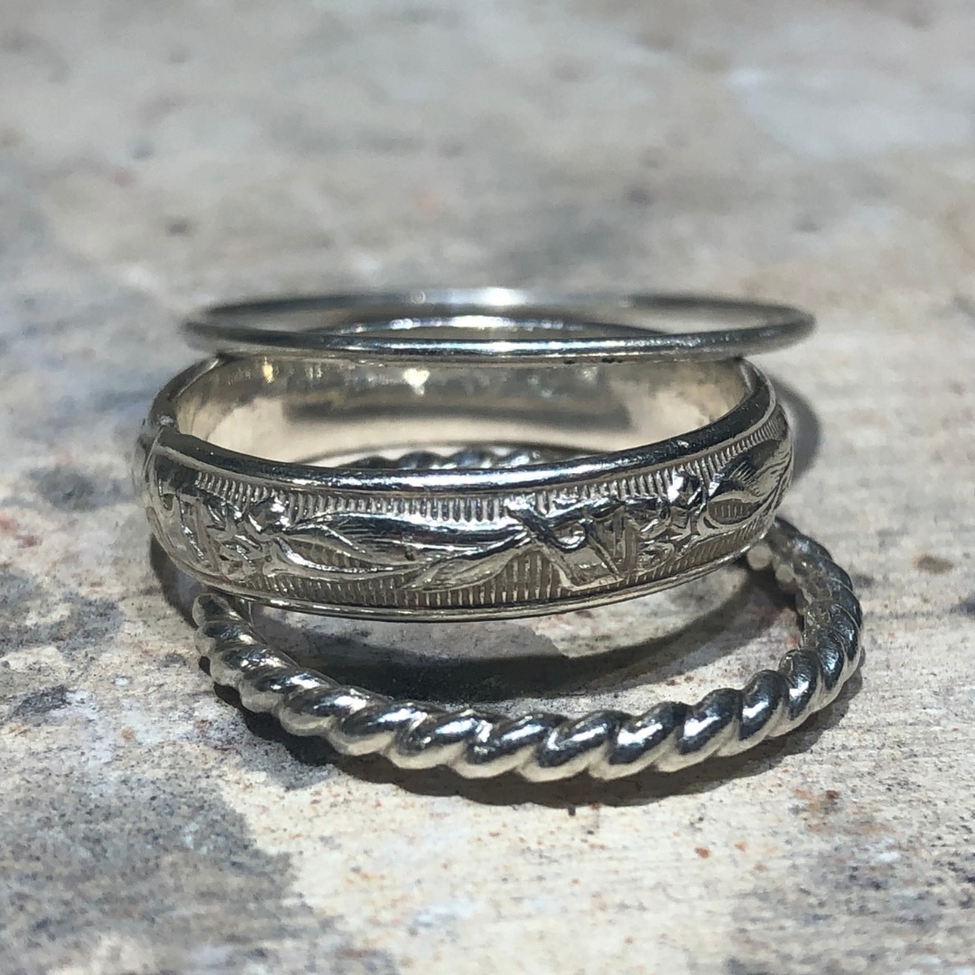a stack of textured silver finger rings