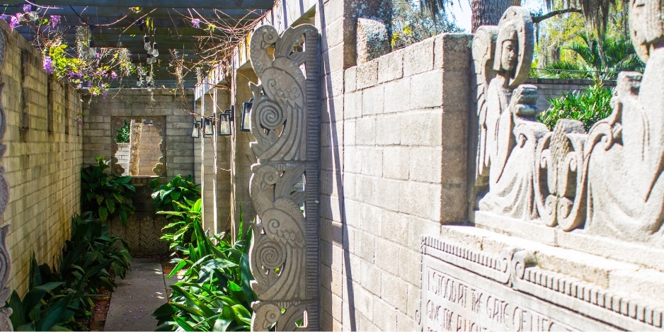 Image of the pathway leading into the Mayan Courtyard on A&H grounds, facing the carvings on the walls.